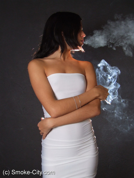 Young teen brunette smokes a cigarette while wrapped in tight white dress and heels - #163677