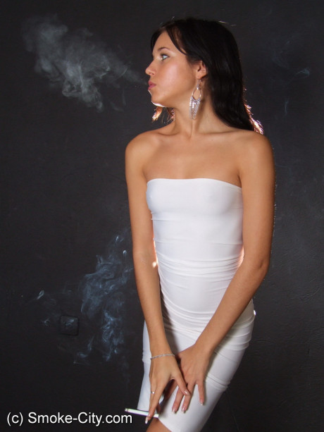 Young teen brunette smokes a cigarette while wrapped in tight white dress and heels - #163678