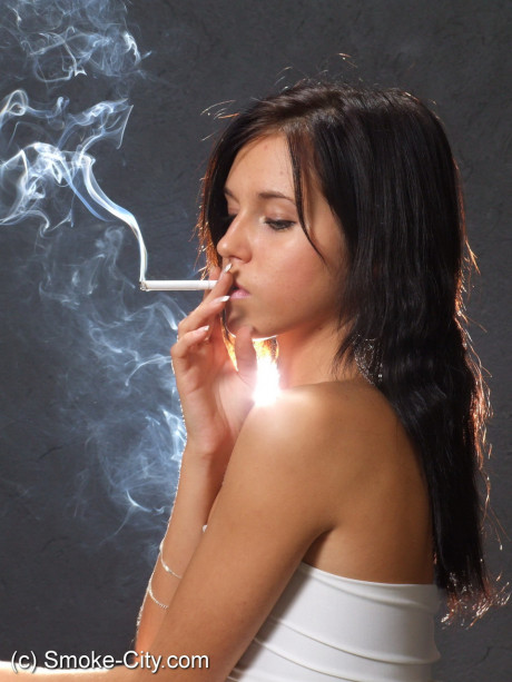 Young teen brunette smokes a cigarette while wrapped in tight white dress and heels - #163691