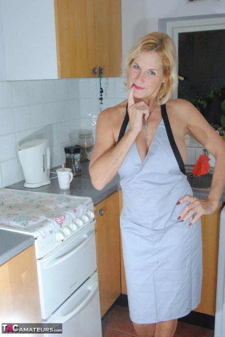 Cougar MILF with blondy hair wears only an apron while devouring a banana - #58674