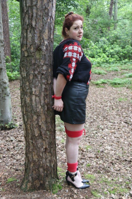 Chunky redhead is cleave gagged and tied to a tree in a forest - #812588