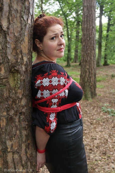 Chunky redhead is cleave gagged and tied to a tree in a forest - #812593