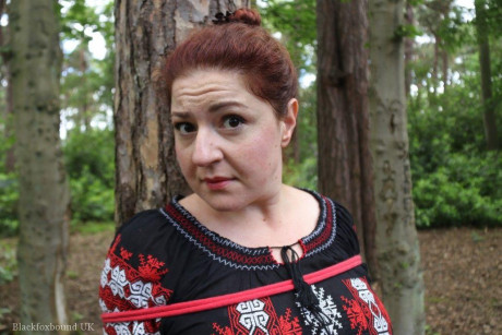 Chunky redhead is cleave gagged and tied to a tree in a forest - #812594