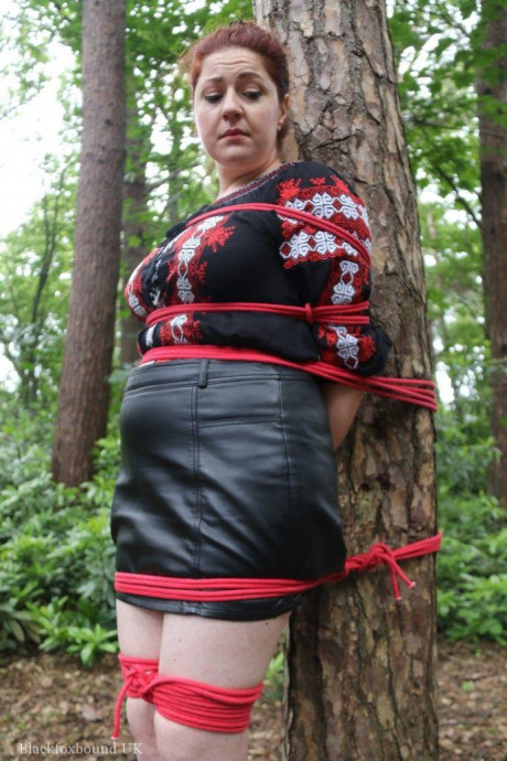 Chunky redhead is cleave gagged and tied to a tree in a forest - #812595
