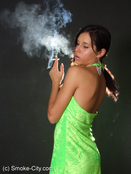 Dark haired young wears a lime dress and pointy heels while smoking - #677279
