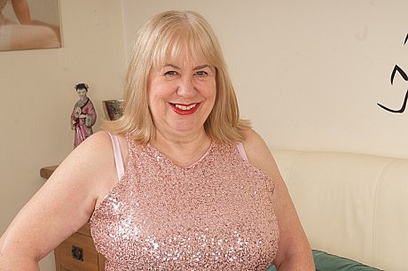 Older blonde Speedy Bee finger mounts her twat on a bed in tan pantyhose