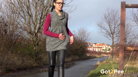 Short taken lady girl girl Esperansa pulls down her leather pants to pee by a bike path