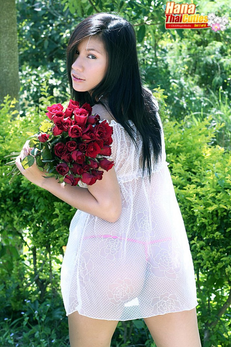 Dark haired Thai chick girlfriend woman Hana holds flowers while showing her boobies and twat