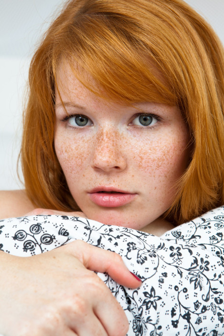 Czech redhead Mia Sollis showcases her medium titties and spreads her bald beaver