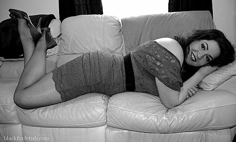 Pale red hair models a red dress and heels on a leather couch - Image 5 of 10  in Pantyhose category  