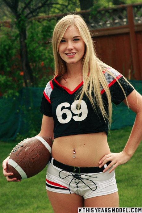 Pretty blondy Jewel doffs sportswear to pose nude while holding a football