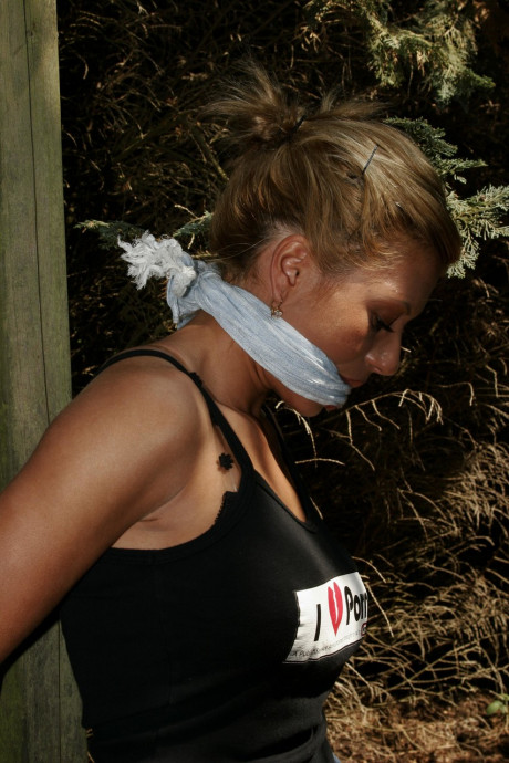 Blondy bitch woman is left bound and gagged to a wooden structure in the woods - #1006261