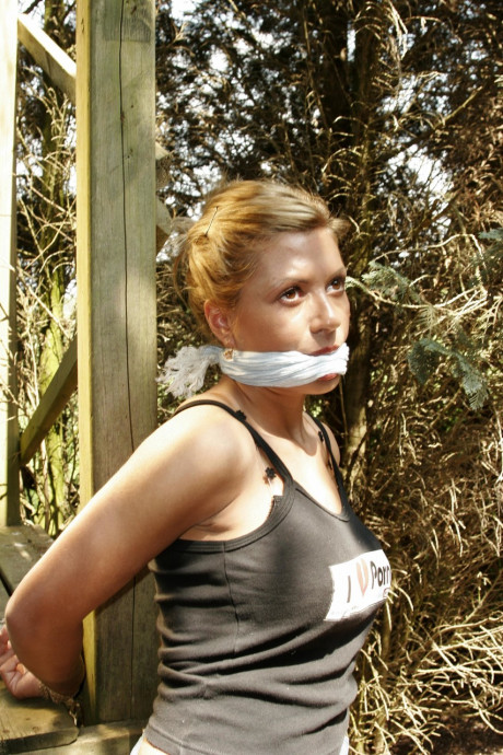 Blondy bitch woman is left bound and gagged to a wooden structure in the woods - #1006271