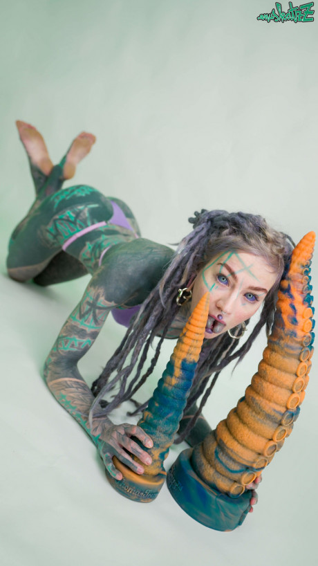 Heavily tattooed chick girl girl Anuskatzz holds a couple of taintacle toys in the naked - #149509