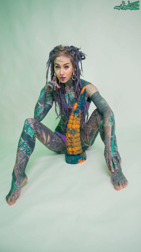 Heavily tattooed chick girl girl Anuskatzz holds a couple of taintacle toys in the naked - #149515