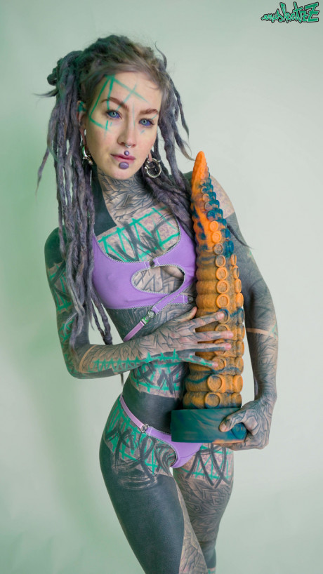 Heavily tattooed chick girl girl Anuskatzz holds a couple of taintacle toys in the naked - #149520
