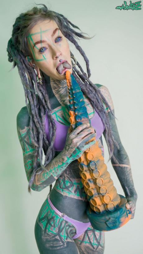 Heavily tattooed chick girl girl Anuskatzz holds a couple of taintacle toys in the naked - #149521