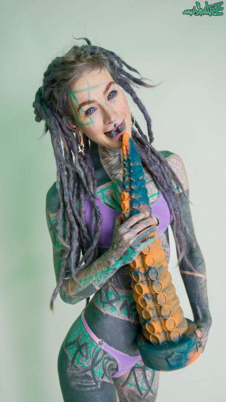Heavily tattooed chick girl girl Anuskatzz holds a couple of taintacle toys in the naked - #149522