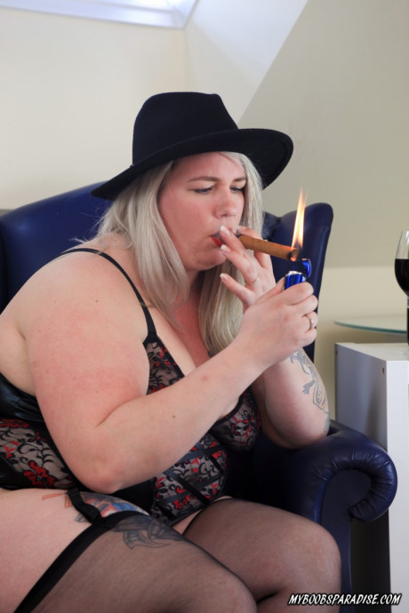 Blonde BBW Bonie lights up a cigar before going topless in a black hat - #886703