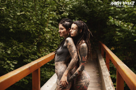 Heavily tattooed lesbians hold each other while totally naked on a bridge - #347735