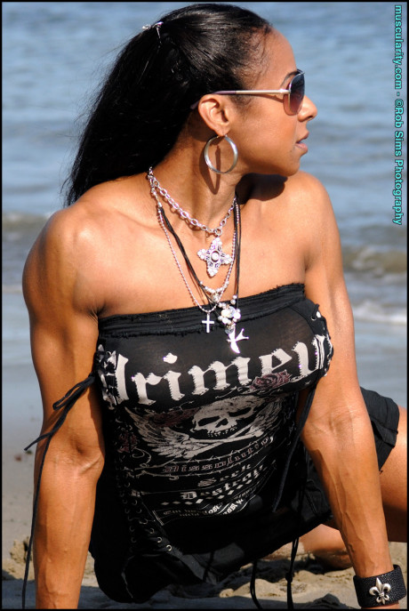 Ebony bodybuilder Stacy Simons flexes on a beach while wearing sunglasses - #377058