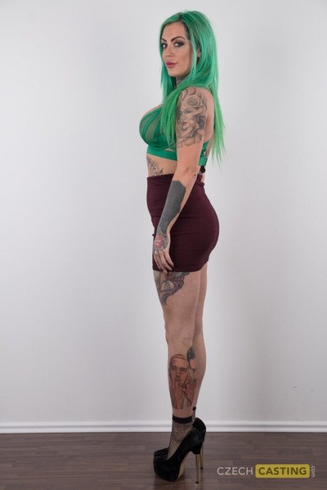 Tattooed slut gf girl with green hair and pierced nipples stands naked after disrobing
