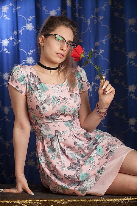 Nerdy 18 year cougar Liza Loo holds a rose showing her firm tits in glasses