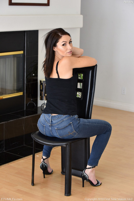 Charming brunette MILF Ashley takes off her ebony top & jeans on a leather armchair - #29216