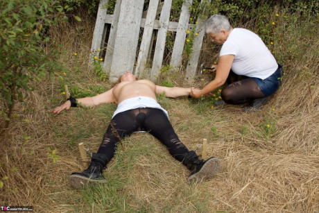 Older British chick restrains busty old skank girl Speedy Bee while in the outdoors - #780377