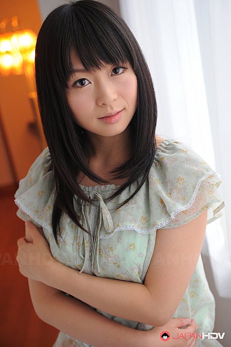 Japanese sweetie Nozomi Hazuki uncovers her perky boobies while getting nude