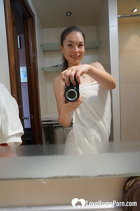 Brunette honey exposes her small tits and takes selfies in the mirror