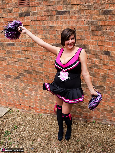 Chubby cheerleader Roxy uncovers her massive melons against a brick wall - Image 2 of 16  in Amateur category   featuring Roxy Anderson 