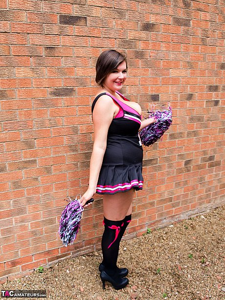 Chubby cheerleader Roxy uncovers her massive melons against a brick wall - Image 3 of 16  in Amateur category   featuring Roxy Anderson 