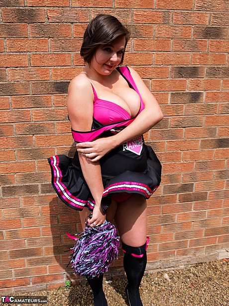 Chubby cheerleader Roxy uncovers her massive melons against a brick wall - Image 9 of 16  in Amateur category   featuring Roxy Anderson 