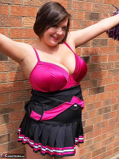 Chubby cheerleader Roxy uncovers her massive melons against a brick wall - Image 11 of 16  in Amateur category   featuring Roxy Anderson 