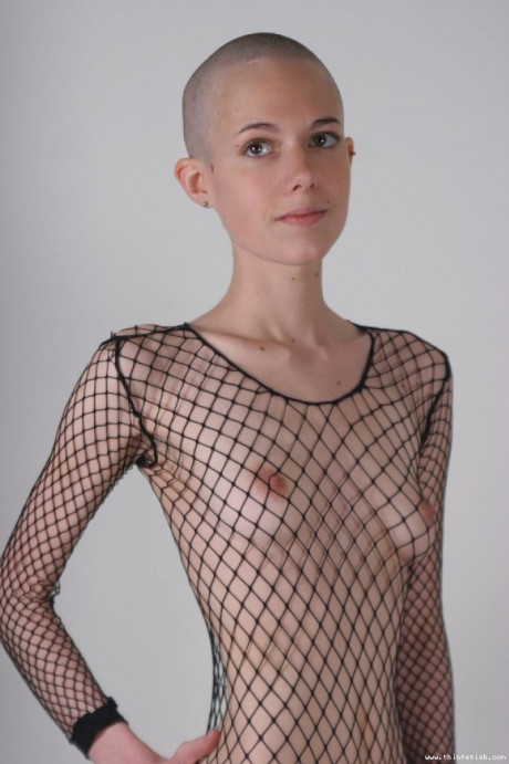 Solo model with a shaved head poses in a fishnet bodystocking - #40207