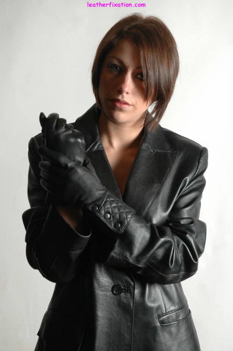 Fully clothed female pulls on a pair of black leather gloves - #1238496