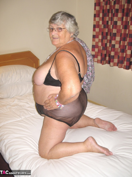 Silver haired British broad granny Libby exposes her meaty body on a bed