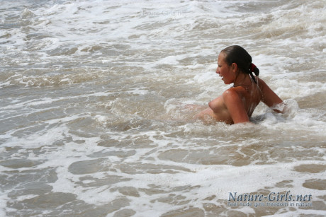 Naked ladies romp about in the ocean surf on a public beach - #1067034