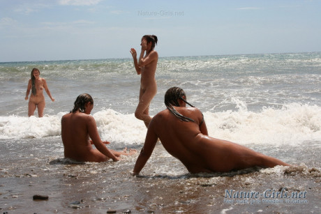 Naked ladies romp about in the ocean surf on a public beach - #1067046