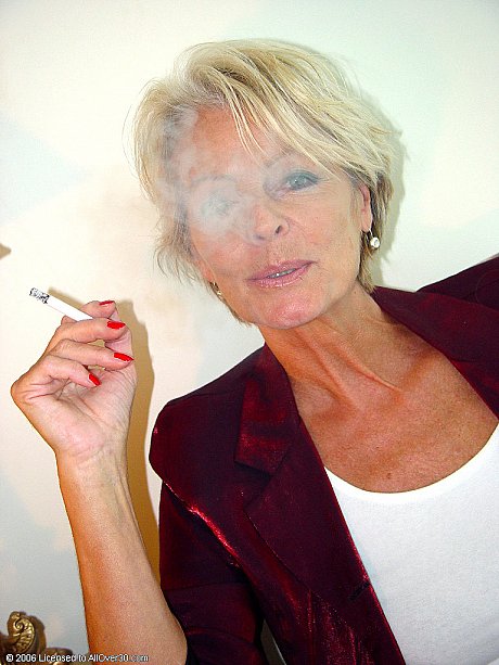 Mature chick lady Justine exposes her saggy tanned breasts while smoking a cigarette - Image 5 of 20  in Legs category   featuring Justine 