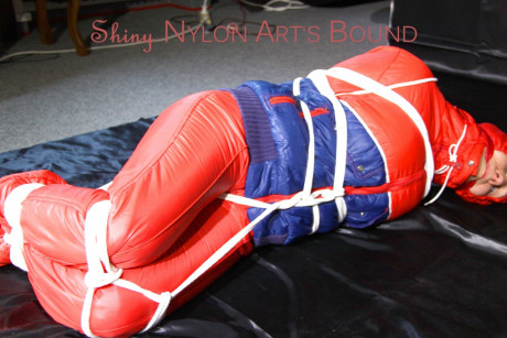 Caucasian lady woman is left tied, gagged and hooded on a sheet of black plastic - #1336109