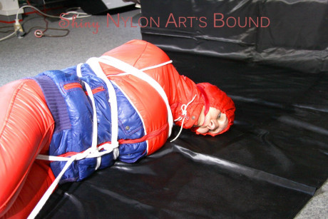 Caucasian lady woman is left tied, gagged and hooded on a sheet of black plastic - #1336112