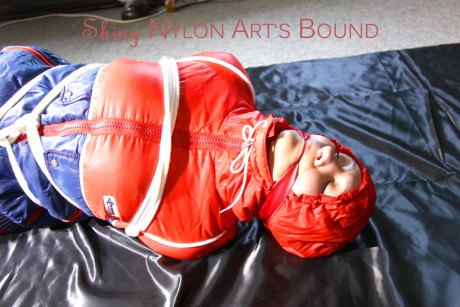 Caucasian lady woman is left tied, gagged and hooded on a sheet of black plastic - #1336113