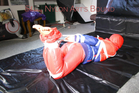 Caucasian lady woman is left tied, gagged and hooded on a sheet of black plastic - #1336116