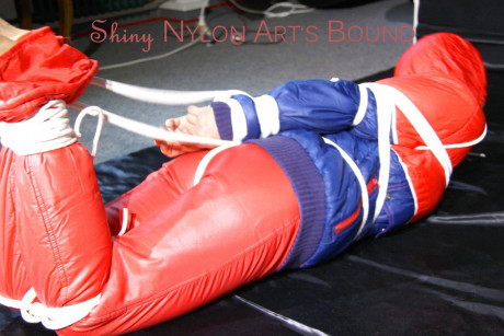 Caucasian lady woman is left tied, gagged and hooded on a sheet of black plastic - #1336117