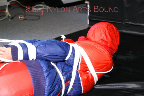 Caucasian lady woman is left tied, gagged and hooded on a sheet of black plastic - #1336118