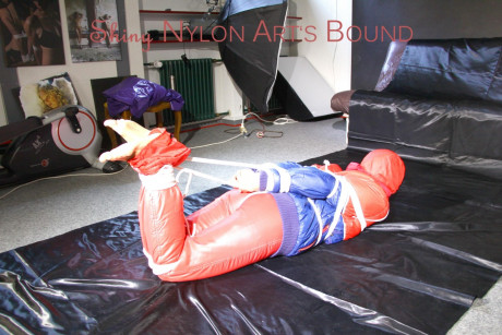 Caucasian lady woman is left tied, gagged and hooded on a sheet of black plastic