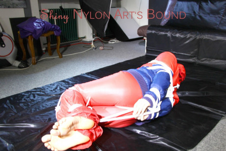 Caucasian lady woman is left tied, gagged and hooded on a sheet of black plastic - #1336121