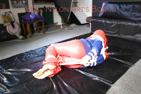 Caucasian lady woman is left tied, gagged and hooded on a sheet of black plastic - #1336122